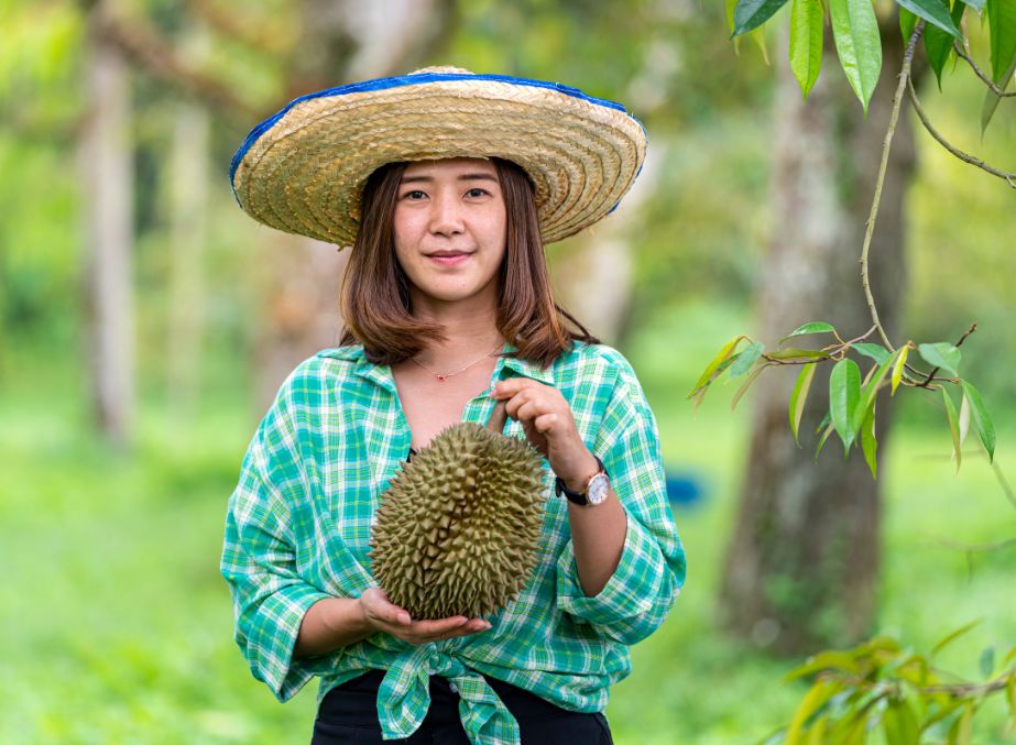 A Thai girl holding the Durian fruit