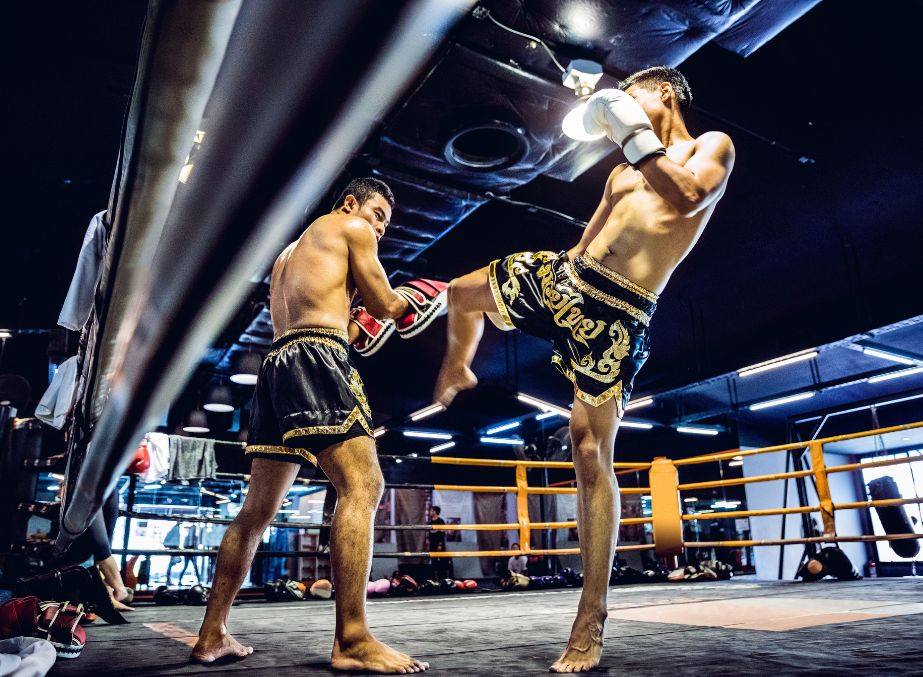 Muay Thai boxers practising combative moves in a boxing ring