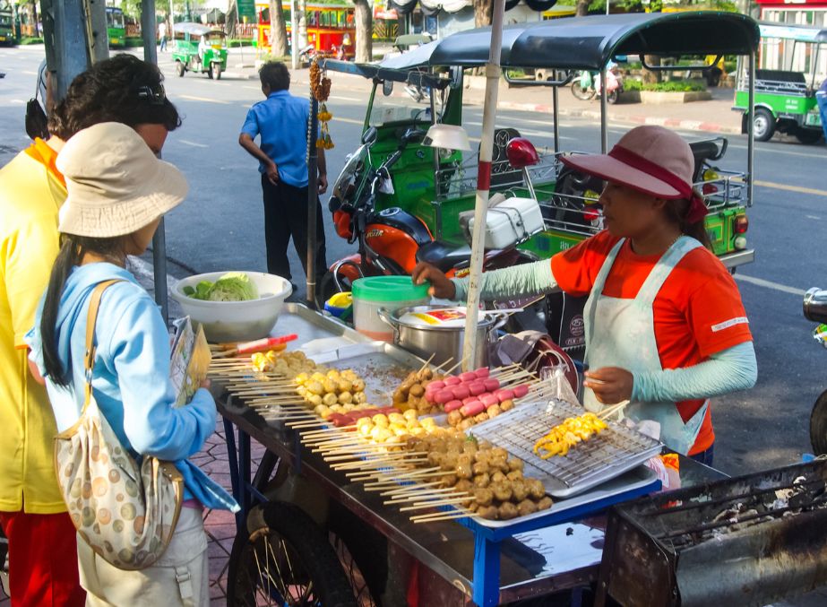 Customers sampling street food in Bangkok